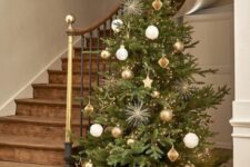 60 a stylish Christmas tree decorated with gold, white and brown ornaments of various shapes, with lights and stars