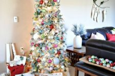 65 a flocked Christmas tree decorated vintage style with silver, pink, red and light green ornaments, fresh greenery and lights looks magical