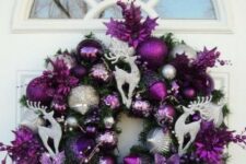 a bright and shiny Christmas wreath made with purple and silver ornaments, purple blooms, beads and silver deer plus a large bow