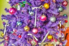 a bright purple Christmas tree decorated with super colorful Christmas ornaments on ribbon bows plus lights is a whimsical solution