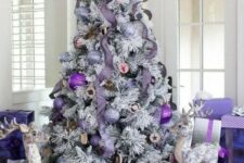 a lovely flocked Christmas tree with purple ornaments