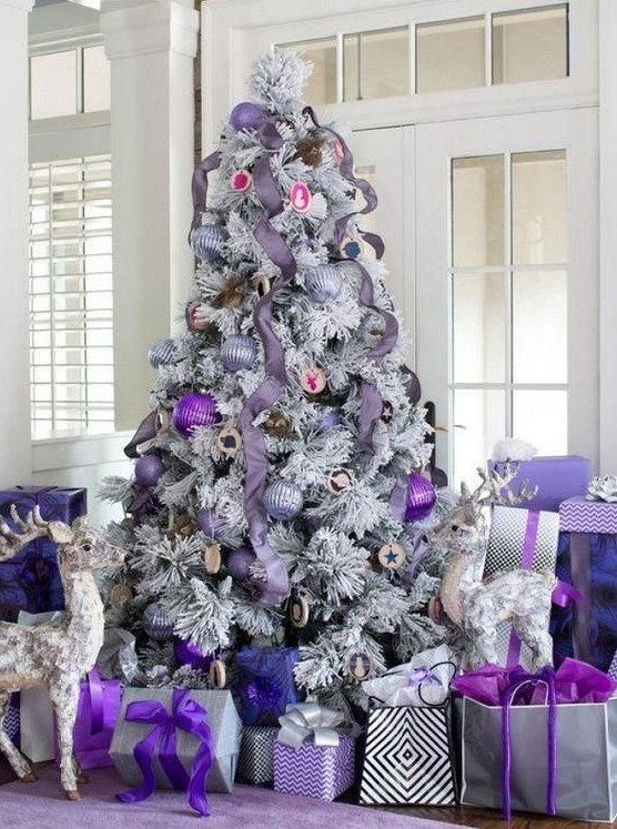 a flocked Christmas tree with lavender ribbons, lilac, silver and bold purple ornaments and lots of gift boxes and bags