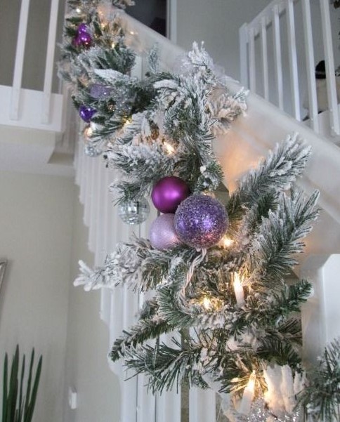 a flocked evergreen garland with lights, purple, blush and lilac ornaments is amazing for Christmas decor in your home