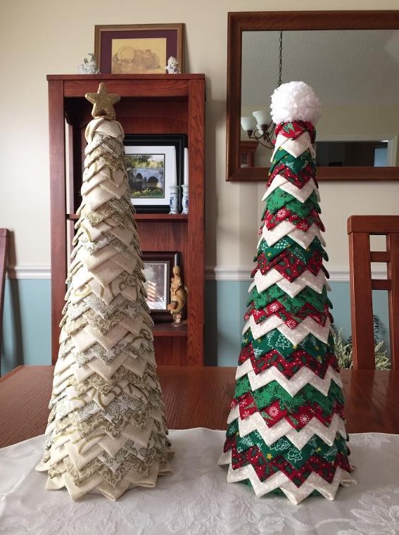 A neutral and green, red and white fabric piece cone shaped Christmas trees, topped with a star and a pompom