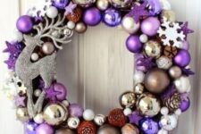 a pretty bright Christmas wreath with lilac, purple, silver and gold ornaments, tiny pinecones and a rhinestone deer is a lovely and bold front door decoration