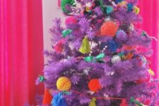 a purple Christmas tree decorated with colorful pompoms and tassels is a lovely idea for a bold holiday space