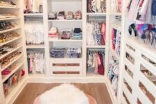 a small and glam closet with open shelves and storage units, drawers with mirror fronts, a pink rug and a faux fur stool is cool