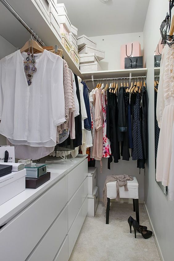 a small and narrow closet done with IKEA items, a large open shelf, a white stool and railings for clothes is a nice space