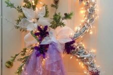 a snowman shaped Christmas wreath with lights, with a gold monogram, a top hat, lights, evergreens and touches of purple