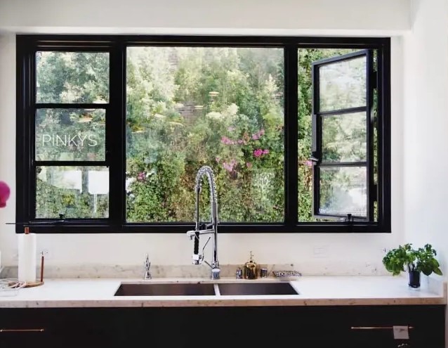 a stylish black and white kitchen with a large casement window that provides light, ventilation and a gorgeous view