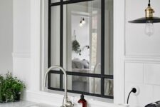 a stylish black frame window from the kitchen to the entryway is a cool idea to fill the entryway with natural light