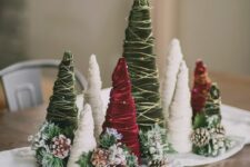 a white napkin, snowy pinecones and evergreens, red, green and white velvet ribbon Christmas trees for a lovely holiday arrangement