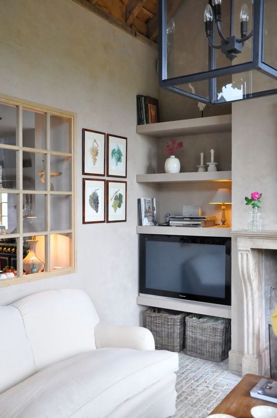 A window with light stained frames connects the kitchen and the living room and lets light inside