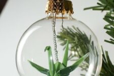 03 a clear Christmas ornament with a green paper crane is a cool idea as cranes in origami symbolize happiness