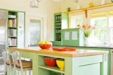 05 a colorful green kitchen with a matching kitchen island, butcherblock countertops, red and yellow accessories and touches