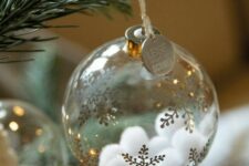 08 a clear glass Christmas ornament with gold snowflakes and white pompoms inside plus a coin is a cool glam idea to rock