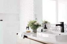 10 a chic Scandinavian bathroom with white hex and square tiles, a floating wooden vanity and black touches here and there