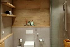 11 a chic minimalist bathroom clad with grey tiles and wood, with a shower space and a tree stump, open shelves for storage
