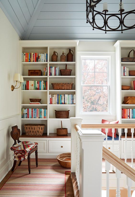 a personalized space done with a large storage unit and a windowsill seat, with a collection of books and baskets