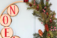 12 a rustic Christmas wreath with evegreens, berries and pinecones, tree slices with red letters and a plaid ribbon on top