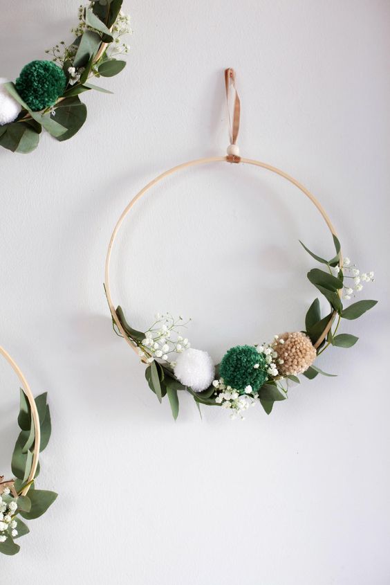 a simple and lovely Christmas embroidery hoop wreath with greenery, baby's breath and pompoms is a lovely decoration for the holidays