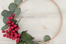15 a simple and quick to make Christmas wreath decorated with greenery and bold red berries is a lovely decoration