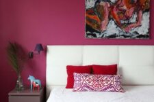 17 a quirky bedroom with a magenta statement wall and bedspread, a statement artwork, a lavender nightstand and purple sconces