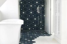 19 a laconic bathroom done with white tiles and navy hexagon tiles with stars that come under the tub