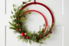 22 an embroidery hoop Christmas wreath in red, with evergreens, pinecones, red ornaments and wooden beads is a cool and chic idea for the holidays