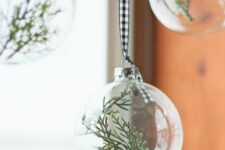 22 clear glass Christmas ornaments with greenery on buffalo check ribbons are great for adding an airy touch to the space