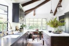 24 a chic modern farmhouse kitchen with a light-stained floor, dark wooden beams and a kitchen island that dominate over the space