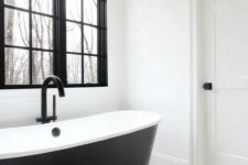 36 a black and white farmhouse bathroom with a black window frame, a sleek black bathtub, a cool chevron floor and a bubble lamp