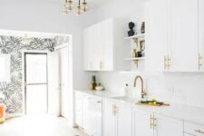 38 a mid-century modern kitchen done in white, with brass handles and faucets