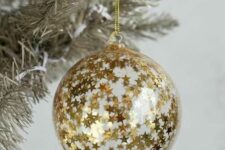 39 a clear glass Christmas ornament fully covered with gold stars is a lovely idea for glam holiday decor