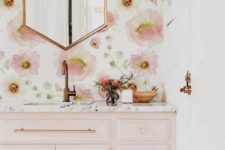 47 a chic and girlish bathroom with pink floral wallpaper, a light pink vanity and gold and copper fixtures and frames