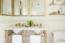 51 a chic bathroom with a retro touch, with gold framed mirrors, a gold vanity stand and gold shelves plus a mosaic floor