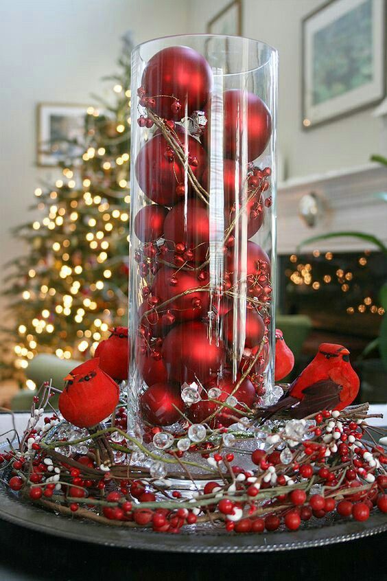 a bold red Christmas centerpiece with red and clear berries, red birds, a glass with red ornaents and berries is amazing