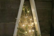 a creative frame Christmas tree with lit up branches and evergreens will be a modern and fresh take on a traditional tree