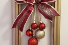 a frame Christmas wreath with red and gold ornaments and an oversized matching bow is a simple craft that looks cool