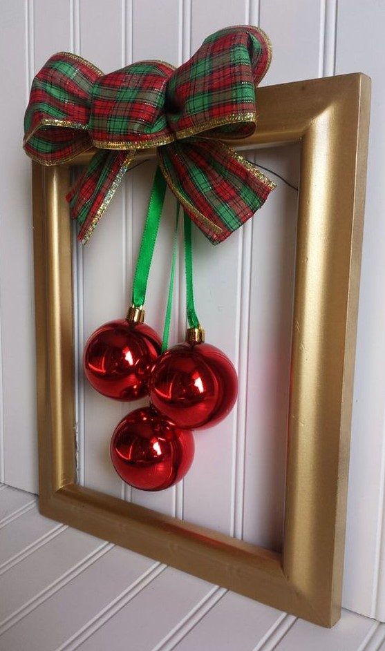 a gold frame Christmas wreath with red ornaments, green ribbon and a green and red plaid bow is a stylish idea