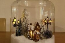 a jar with faux snow, a mini house, some bottle brush Christmas trees and street lights is an amazing Christmassy terrarium
