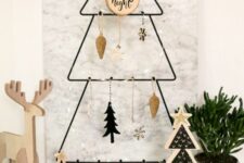 a metal frame Christmas tree with various wooden ornaments and a tree slice is a lovely idea for a Scandinavian space