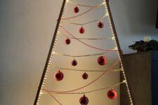 a minimalist frame Christmas tree lined up with lights, with gold and red beads and ornaments is a stylish idea