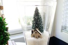 a pretty Christmas terrarium with faux snow, a cardboard house and a bottle brush tree is a lovely idea