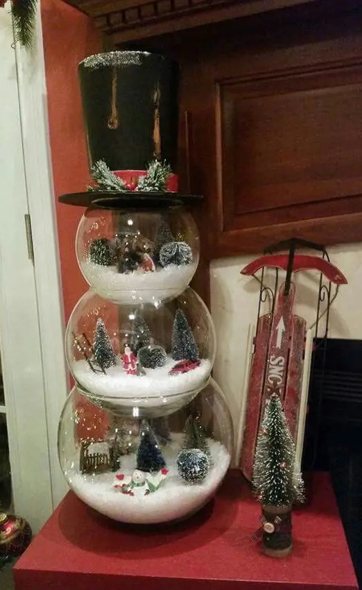A snowman made of three glass terrariumsshowing some lovely and cozy winter scenes is a whimsy idea