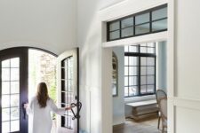 a stylish opening with a transom window with black framing and vintage dark-stained arched doors highlight the vintage style of the space
