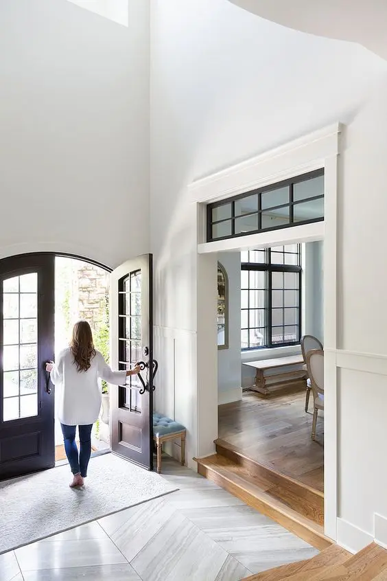 a stylish opening with a transom window with black framing and vintage dark-stained arched doors highlight the vintage style of the space