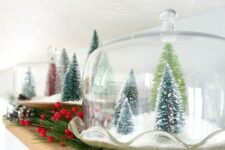 a vintage cloche with faux snow and green bottle brush trees is a lovely Christmas decoration