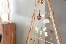 a wooden frame Christmas tree with lights, white, copper, silver and clear ornaments hanging on it and a star topper is a fresh idea to try