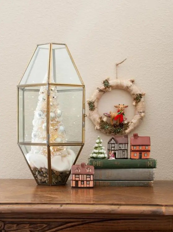 an elegant Christmas terrarium with faux snow, a white bottle brush Christmas tree with pearly ornaments
